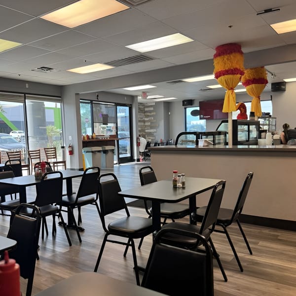 Interior of Generations Kitchen Hawaiian Food, with tables, chairs, and a counter, decorated with festive lanterns.